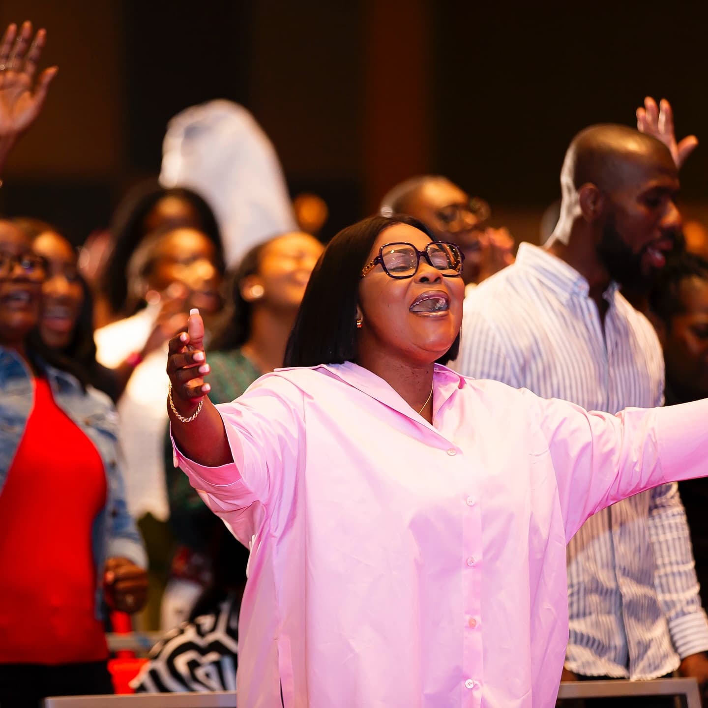 A woman worshipping with arms open